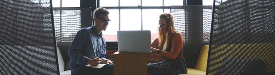 Photo of two business people and a laptop computer.