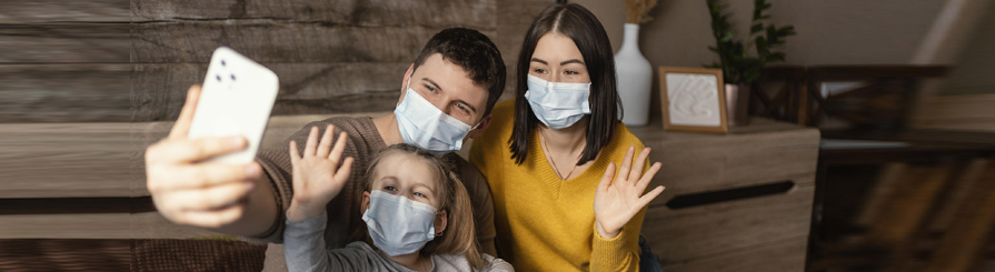 Family wearing masks taking a selfie.