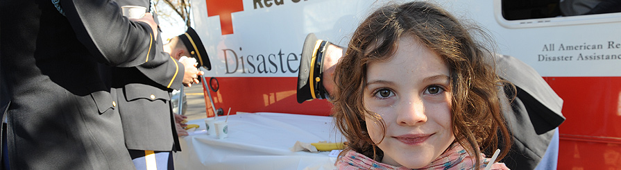 young girl in front of American Red Cross van.
